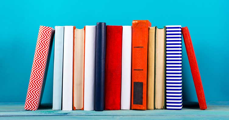 colourful books stacked against blue background