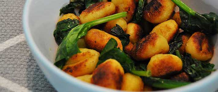 gnocchi and spinach in a bowl