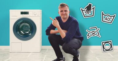 man next to washing machine and washing symbols