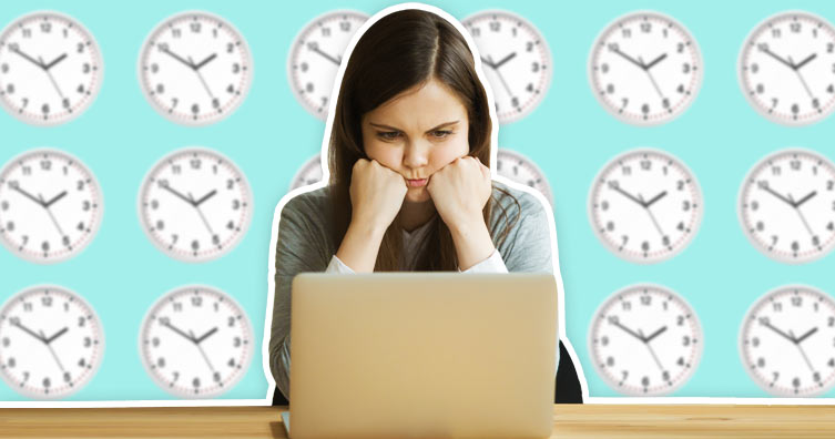 Stressed unhappy girl behind laptop with clocks on the wall
